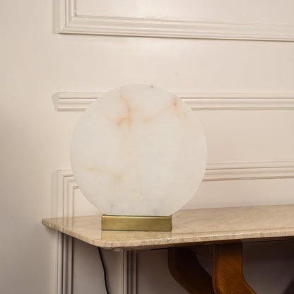 Round marble table lamp unlit on white background with metal base showcasing minimalist design perfect for elegant interior settings.