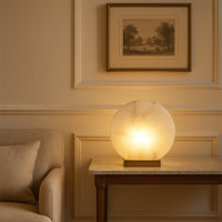 Designer marble table lamp with round stone panel and gold base casting warm light adding elegance to luxury homes and offices.