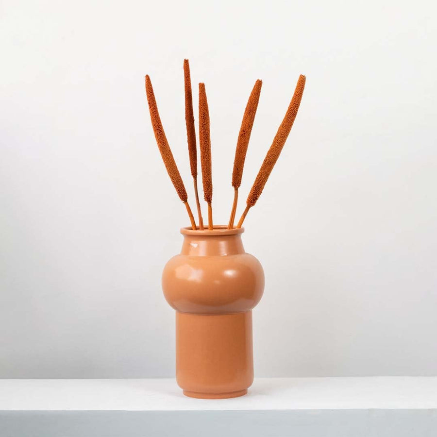 Black bulrush stems displayed in a contemporary setting with minimalist sculpture perfect for luxury home decor.
