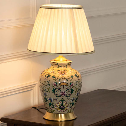 Floral ceramic table lamp with pleated fabric shade adding elegant traditional decor and cozy ambient lighting indoors.