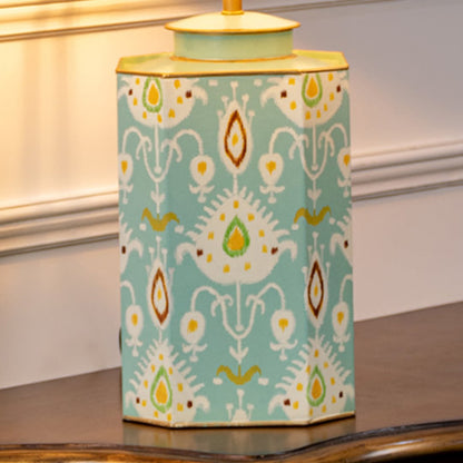 Table lamp closeup showing teal ceramic base with hand painted ikat pattern and gold trimmed edges.
