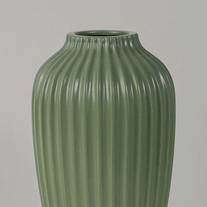 Closeup view of the green ribbed vase showing the detailed vertical grooves and smooth ceramic finish with clear focus on texture and shape.