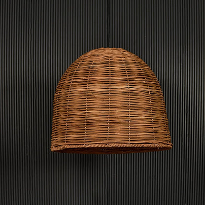Natural rattan pendant light on black background highlighting its handcrafted texture and shape.