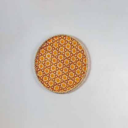Side view of woven bamboo basket tray showing depth and handcrafted construction with orange floral geometric pattern detail.