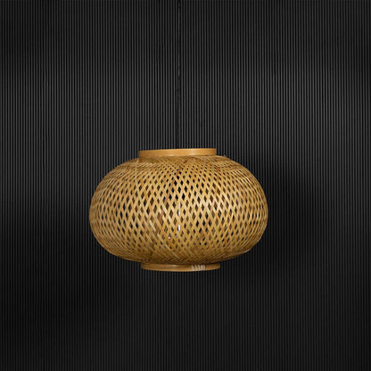 Round rattan pendant light with woven bamboo shade in natural finish turned off against black background.