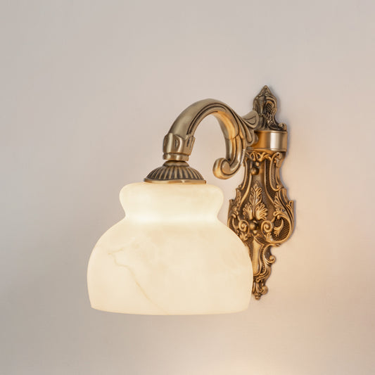 Vintage brass metal wall light with white glass shade for bedroom hallway and elegant home interiors with warm lighting.