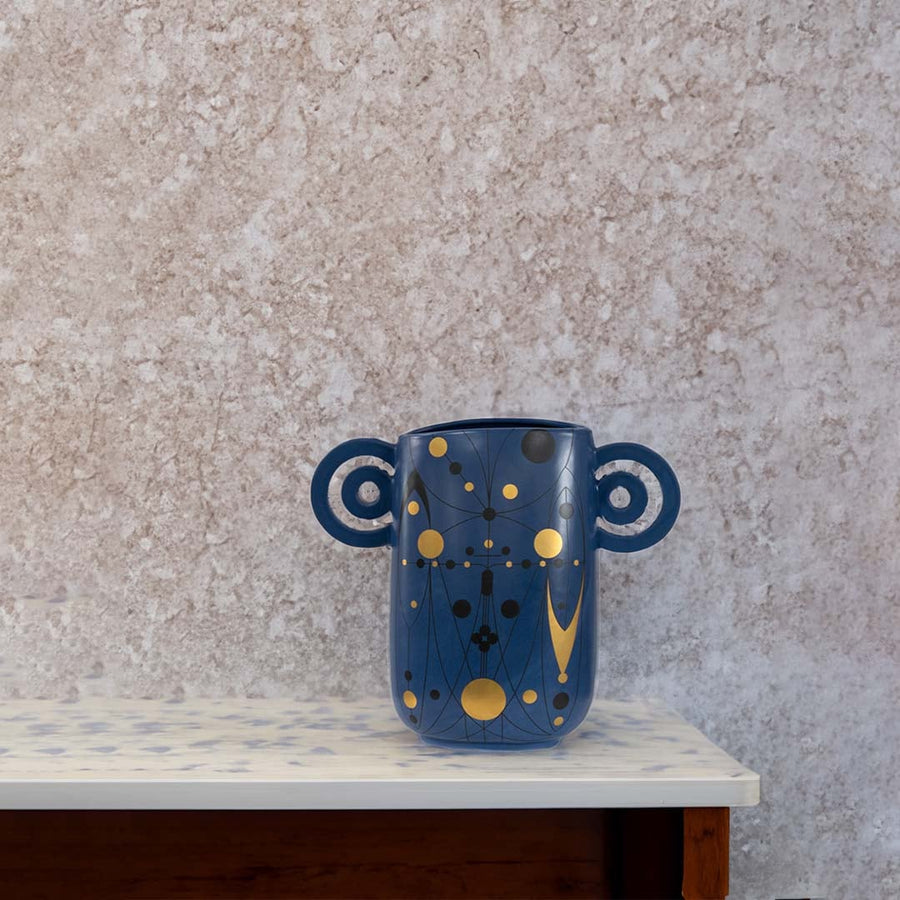 Navy blue abstract ceramic vase with loop handles placed in a stylish modern interior perfect for living rooms and artistic decor accents.