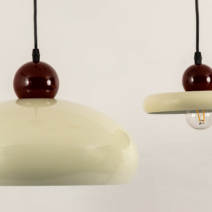 Cream metal pendant lights with burgundy accents illuminated to showcase modern decorative ceiling lighting elegance.