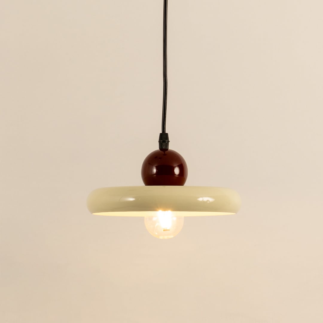 Cream metal pendant light with burgundy accent illuminated to showcase modern ceiling lighting and warm ambient glow.