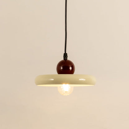 Cream metal pendant light with burgundy accent illuminated to showcase modern ceiling lighting and warm ambient glow.