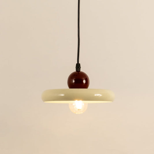 Cream metal pendant light with burgundy accent illuminated to showcase modern ceiling lighting and warm ambient glow.