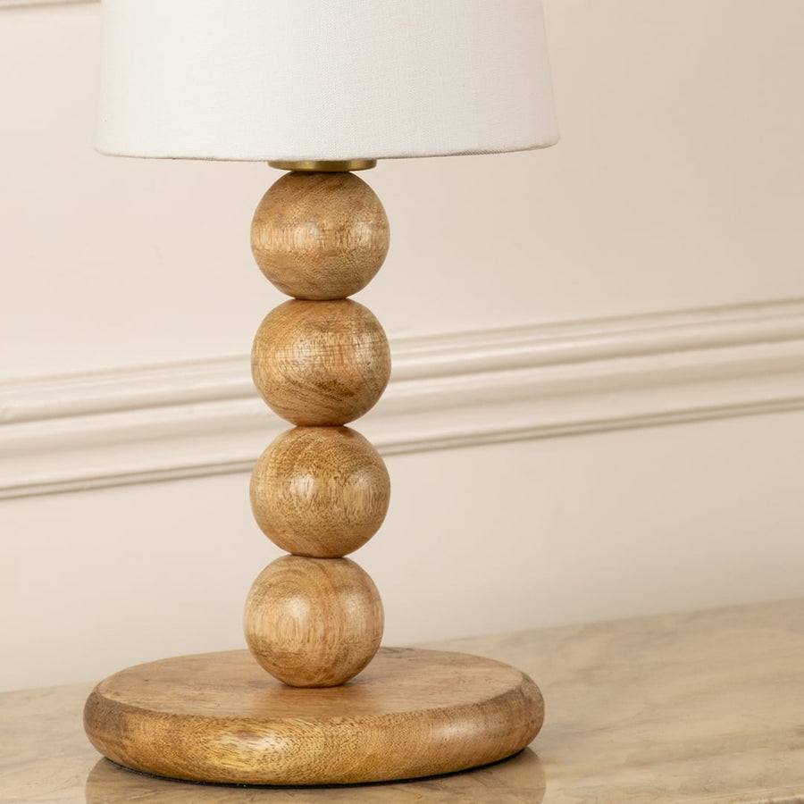 Natural wood bead table lamp base with organic grain texture showcasing artisan craftsmanship and timeless elegance.