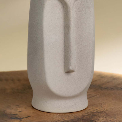 Closeup image of ceramic vase base with sculpted vertical detailing showing matte finish neutral color and refined craftsmanship.