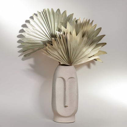 Beige ceramic face vase shown on a white background emphasizing its textured finish and minimal facial silhouette.