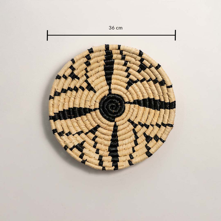 A handwoven natural and black rattan wall decor plate displayed on a white background with a clearly marked diameter of 36 cm for accurate wall decor measurements.