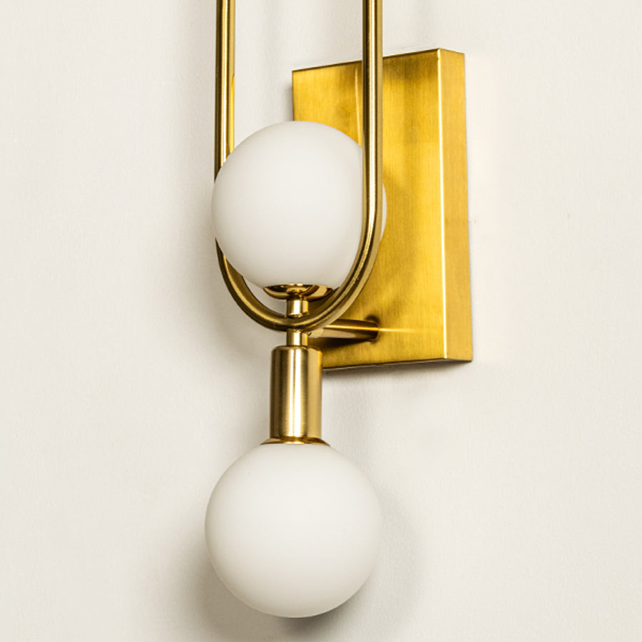 Wall light with dual white glass globes and gold metal frame ideal for modern bedroom or hallway wall decor placement.