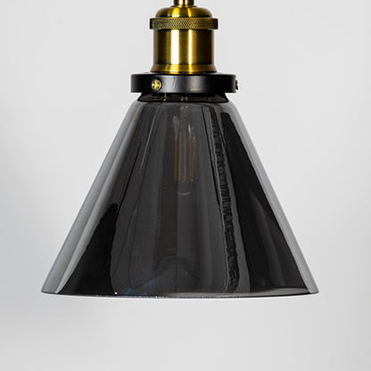 Closeup of smokey glass pendant light with brass top and black fitting designed for elegant home interior lighting.