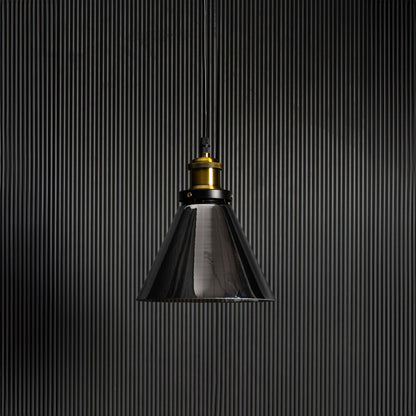Smokey glass pendant light with bulb off on black background featuring brass and black fitting for modern decor.