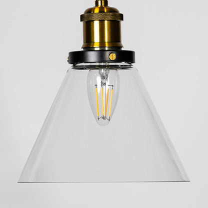 Closeup of glass pendant light with transparent shade and brass black fitting for elegant interior lighting.