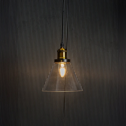 Stylish glass pendant light glowing on black background with modern brass and black metal fitting design.
