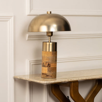 Minimalist dome table lamp in brushed gold and wood finish standing gracefully even when unlit making it a timeless piece for modern decor styling.