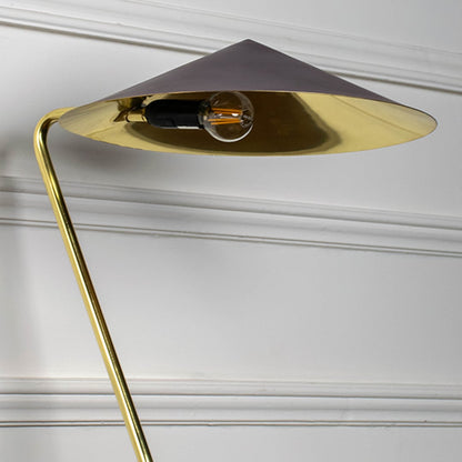 Closeup of gold metal table lamp with dark brown conical shade showing sleek angled stand and contemporary design.