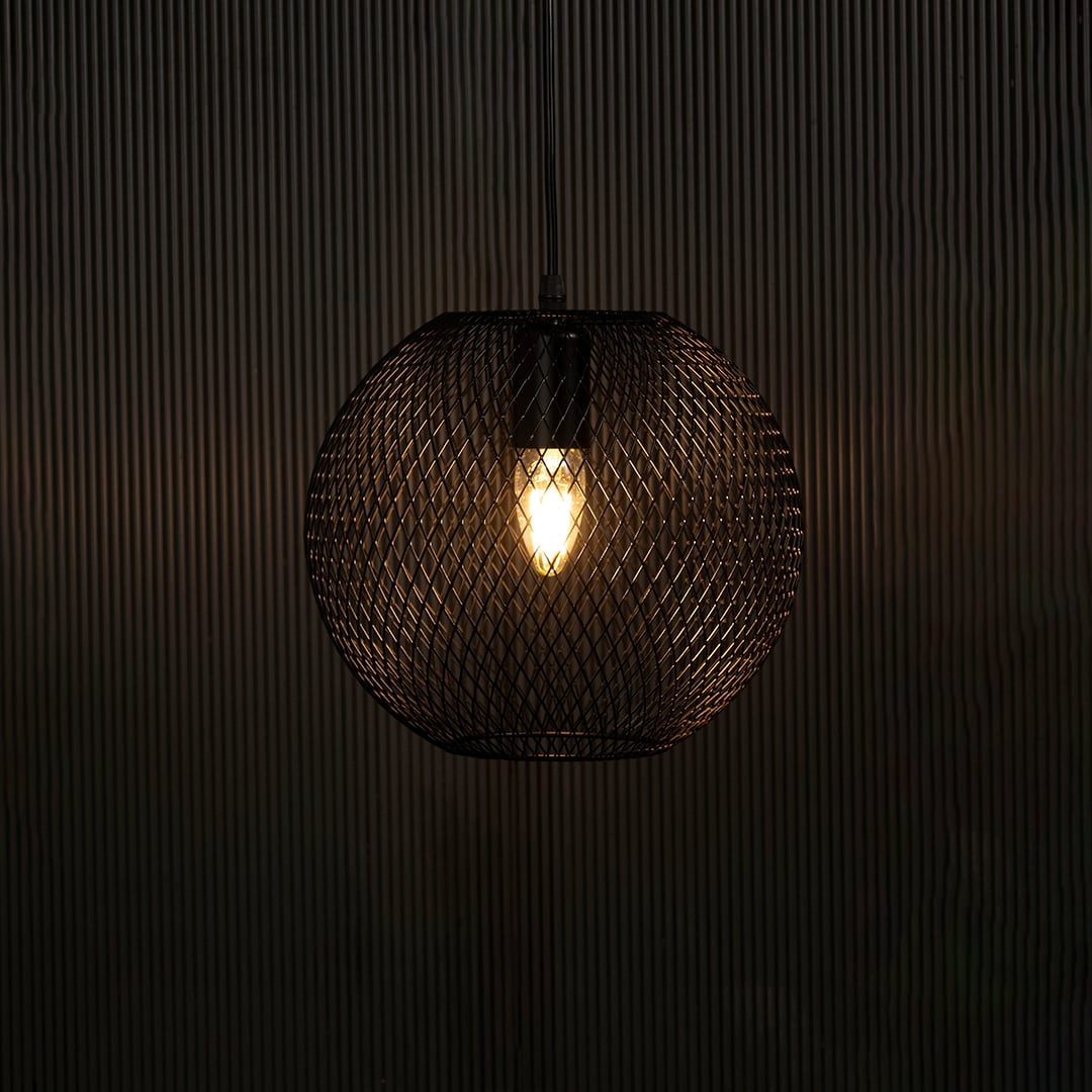Elegant black metal pendant light illuminated on dark background highlighting intricate mesh detailing and modern industrial style.