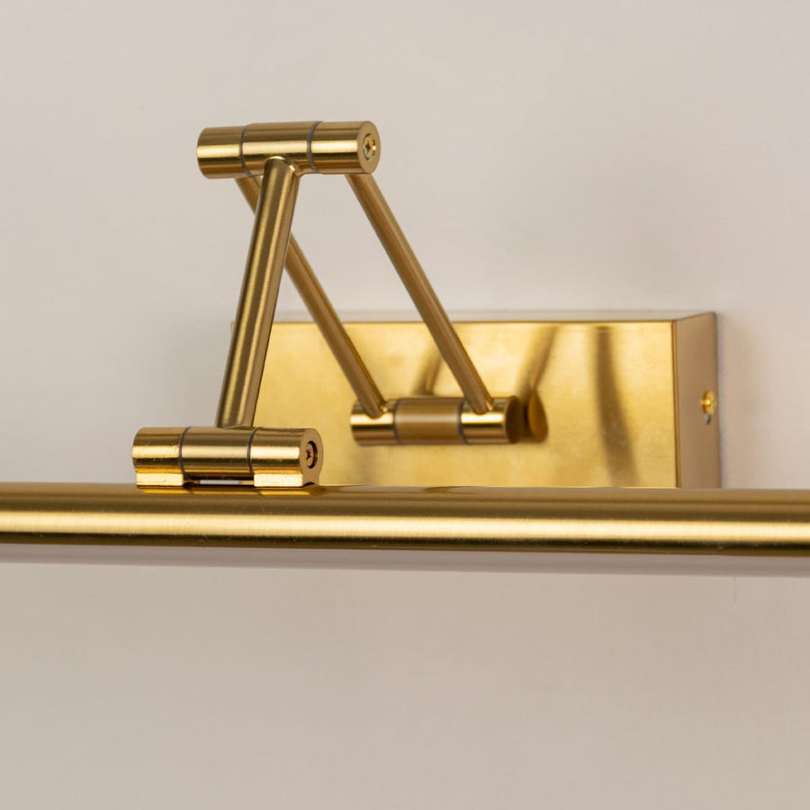Closeup of gold adjustable picture light showing sleek metal finish and arm details for modern wall decor and art lighting.