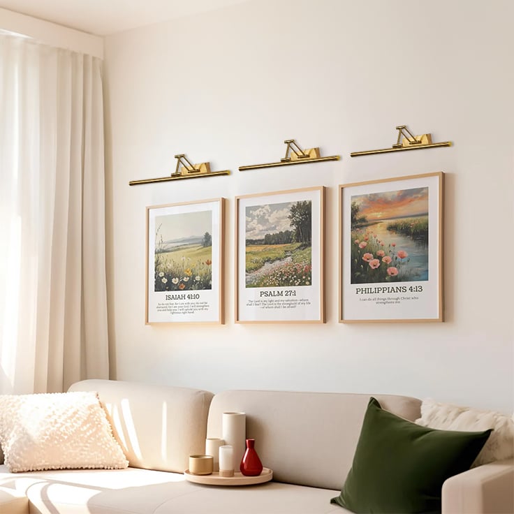 Gold picture light enhancing artwork in a modern interior bringing warm focused lighting to living room and hallway wall decor.