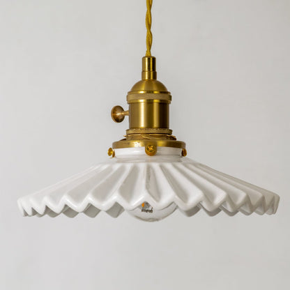 Detailed view of white ceramic and gold metal pendant light with decorative edge design and finish.