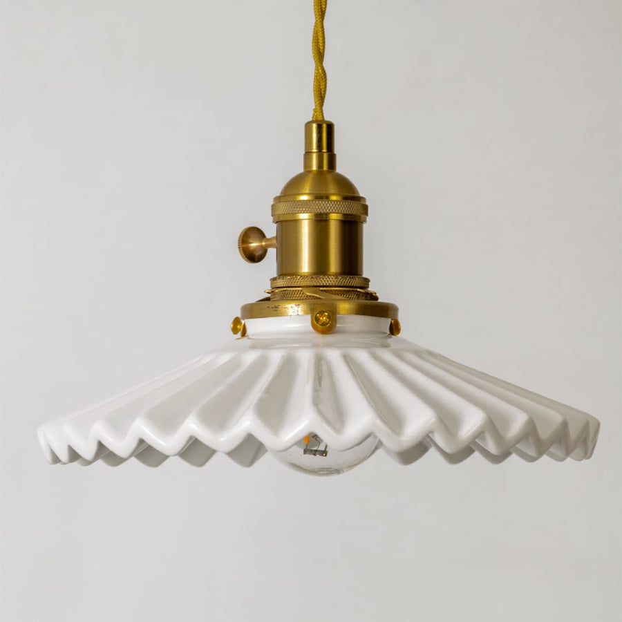 Detailed view of white ceramic and gold metal pendant light with decorative edge design and finish.