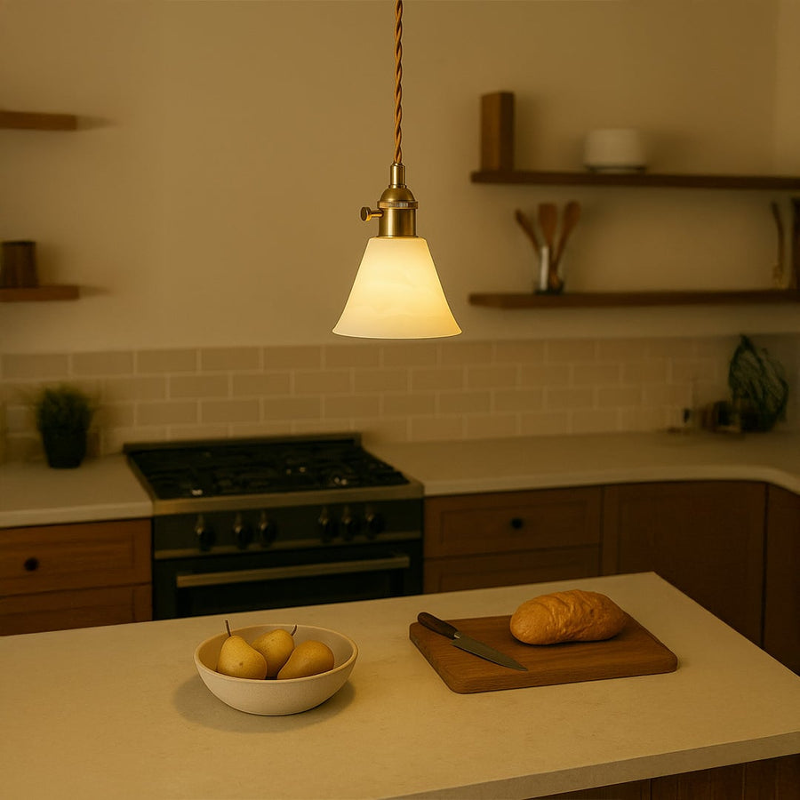 Gold metal pendant light above kitchen island creating warm ambient lighting in modern interiors.