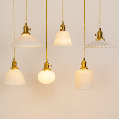 Round ribbed white glass pendant lights with gold metal holders arranged together for stylish kitchen dining and living decor.