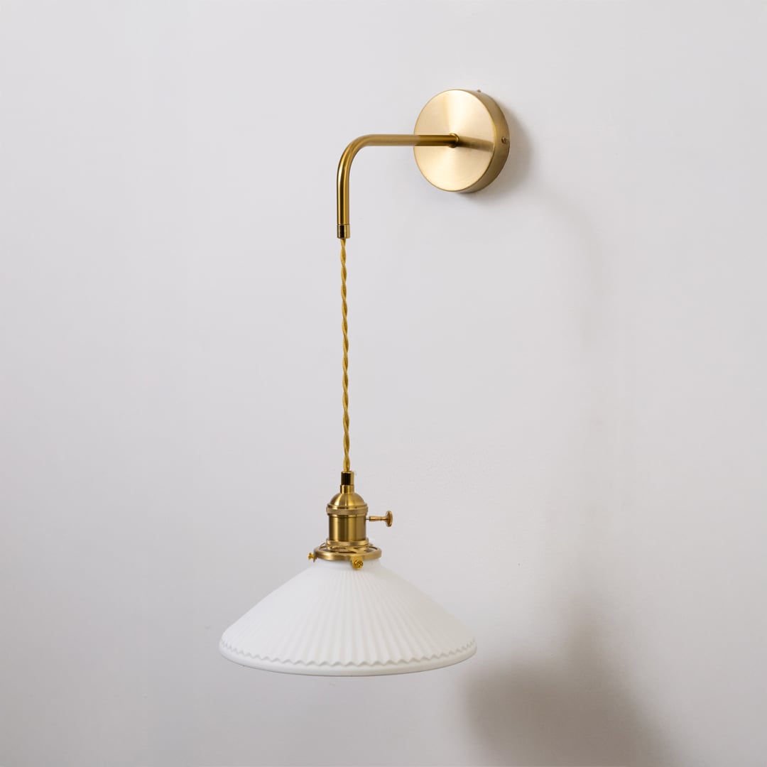 Gold metal wall light with white ribbed shade shown switched off on white background for minimal stylish wall decor.