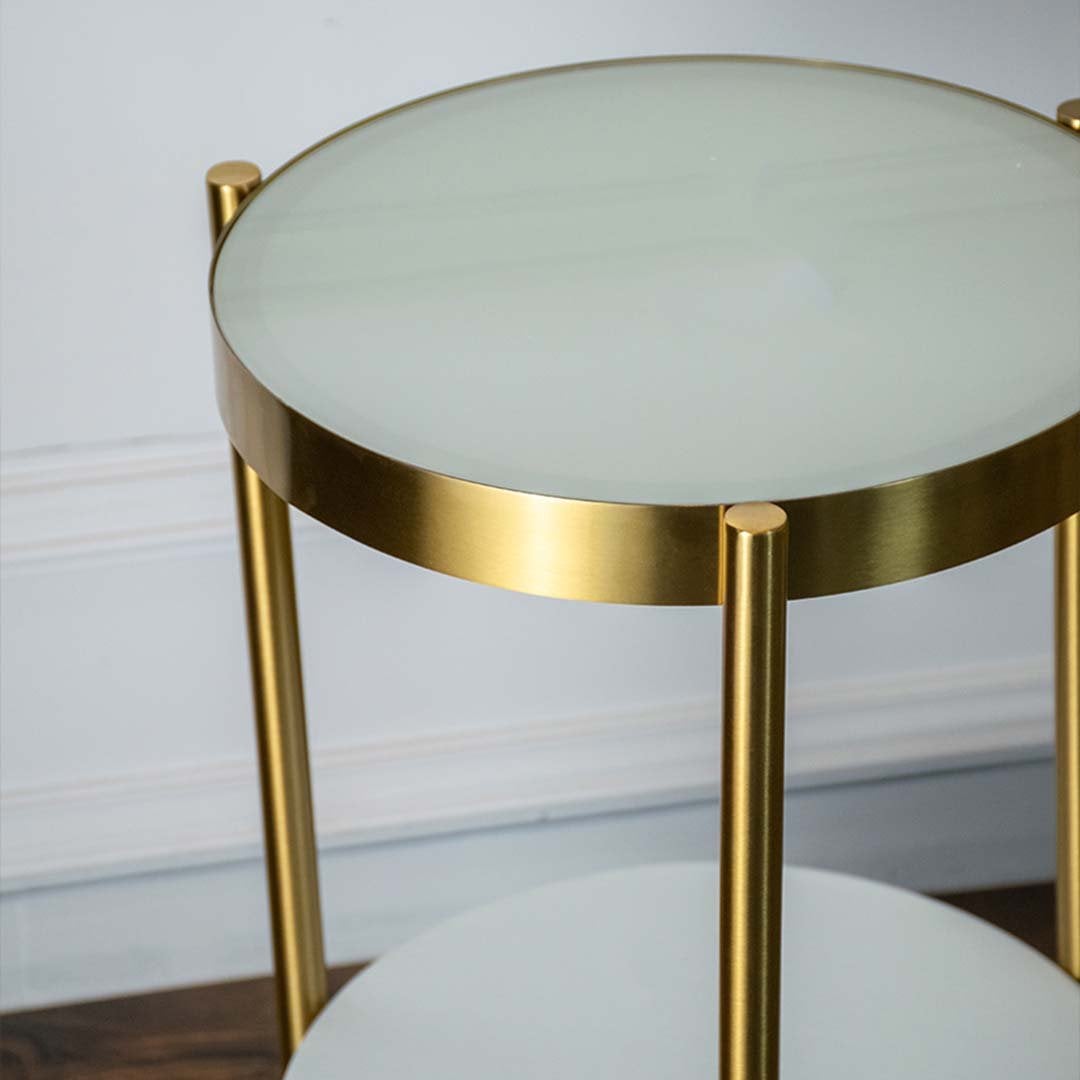 Detailed view of feather lampshade gold curved stand and round side table with drawer storage.