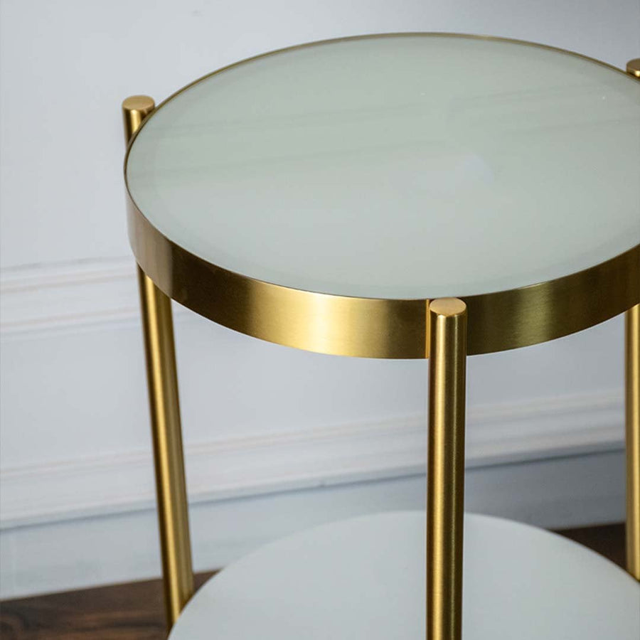 Detailed view of feather lampshade gold curved stand and round side table with drawer storage.