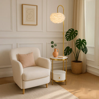 Feather shade gold floor lamp with side table and drawer turned on styled beside armchair in cozy living room.
