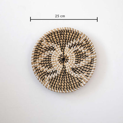 Handwoven round wall basket in natural and black fiber showing 25 cm diameter suitable for decorative interior wall decor placement.