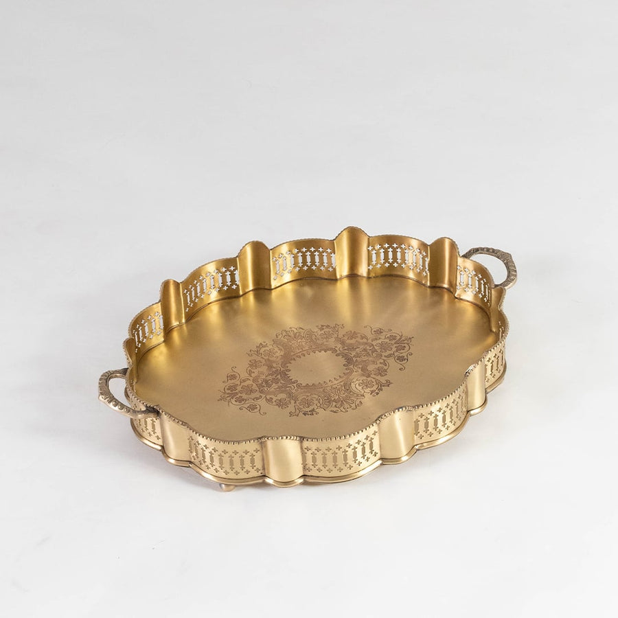 Round gold brass serving tray with ornate edge and floral center engraving photographed on white background for clarity.
