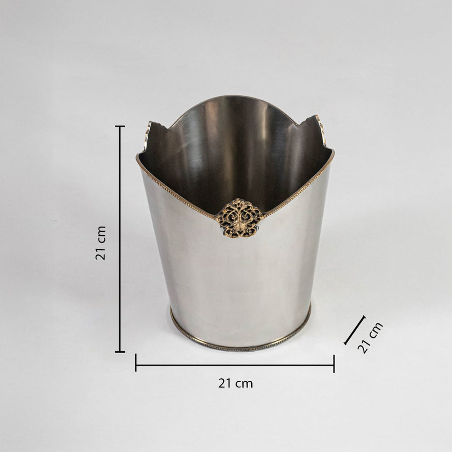 Stainless steel bin with 27 cm height 21 cm width and 20 cm depth shown with gold crest detail and rounded base.