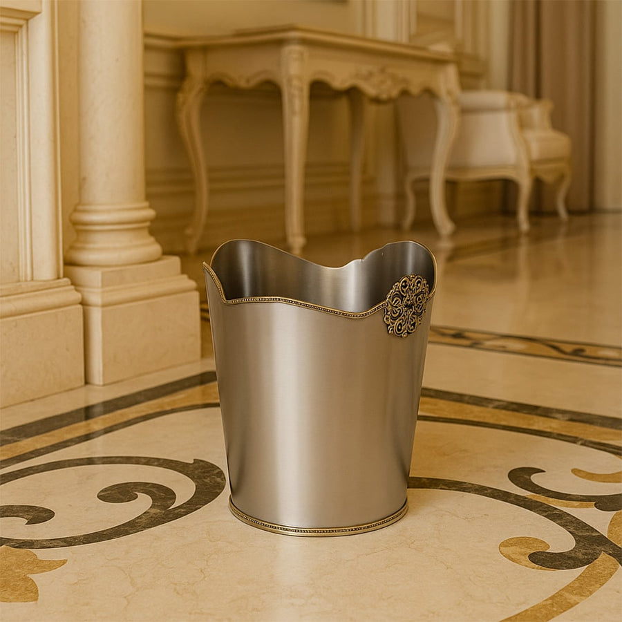 A premium silver dustbin with ornate detailing placed on a marble floor in a luxurious hallway enhancing the sophisticated look of the interior space.