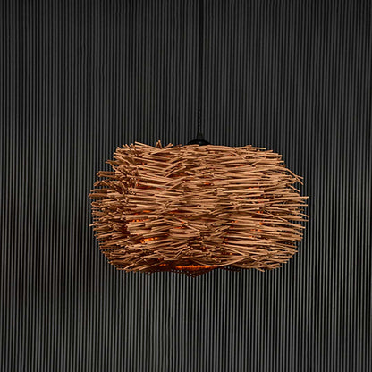 Rattan twig pendant light on black background highlighting its intricate natural weave and organic handcrafted texture.