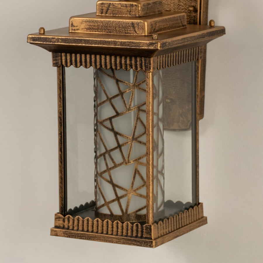 Closeup of gold metal outdoor lantern showing patterned glass panels and rich textured finish capturing its warm elegant exterior look.