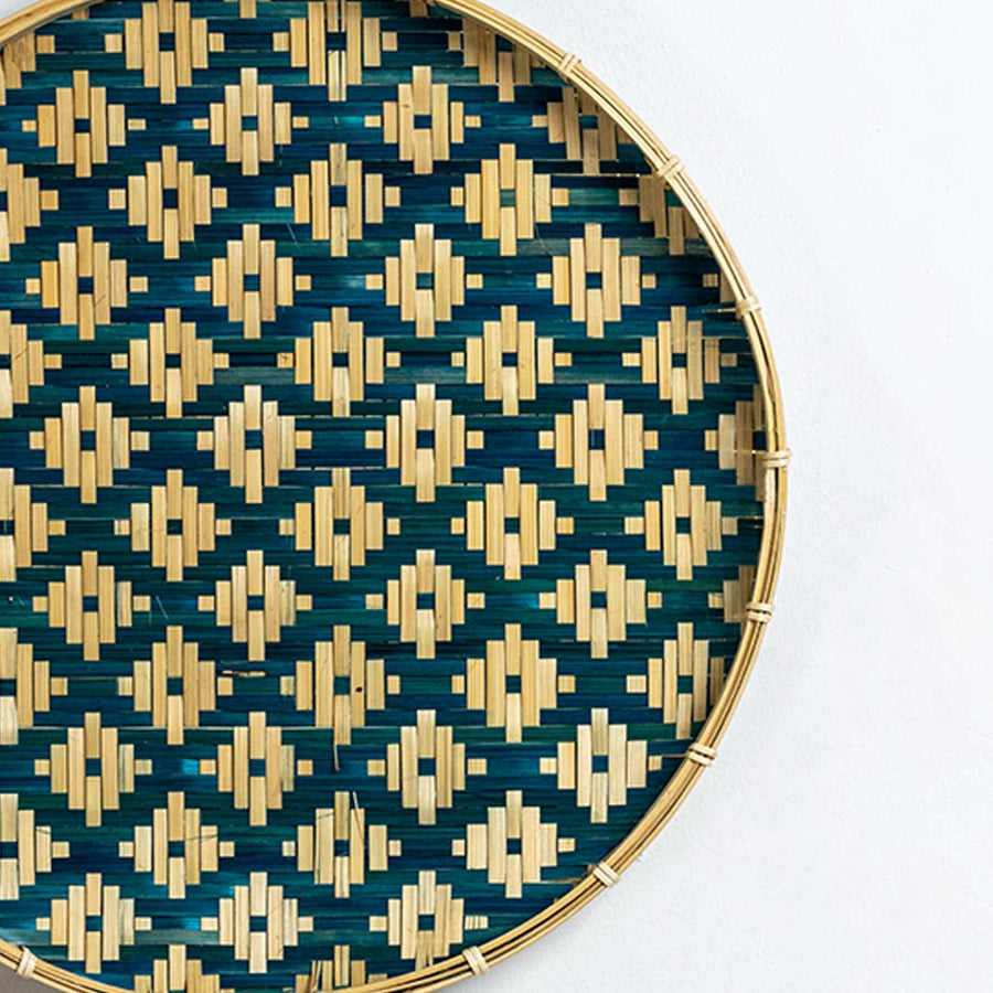 Closeup view of woven wall basket with teal and natural diamond pattern showcasing detailed handweave texture and decorative finish.