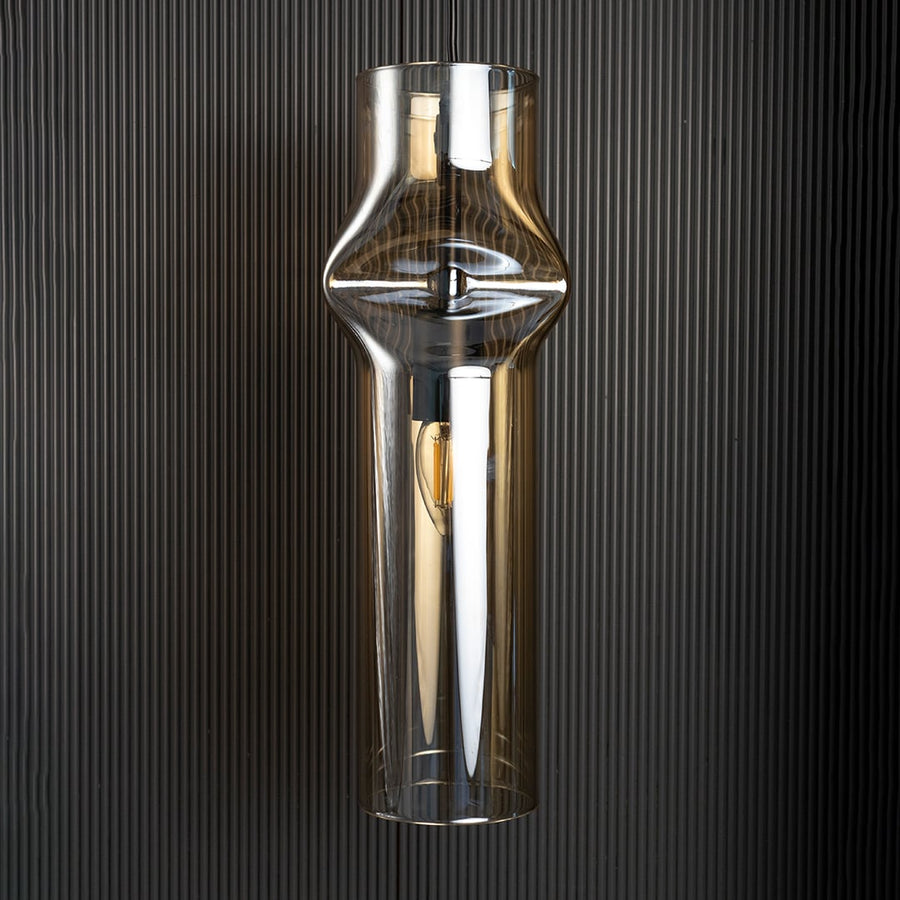 Chrome pendant light turned off reflecting soft highlights against dark backdrop highlighting its elegant industrial design.