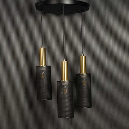 Triple mesh pendant light with gold accents and black perforated shades shown against a black background emphasizing its geometric form.