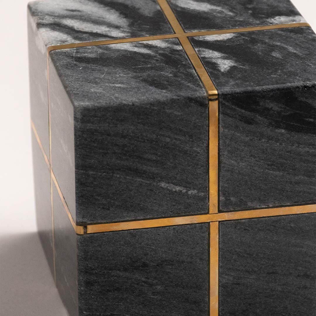Closeup of black marble decorative storage box with gold metal detailing highlighting luxury craftsmanship and design.