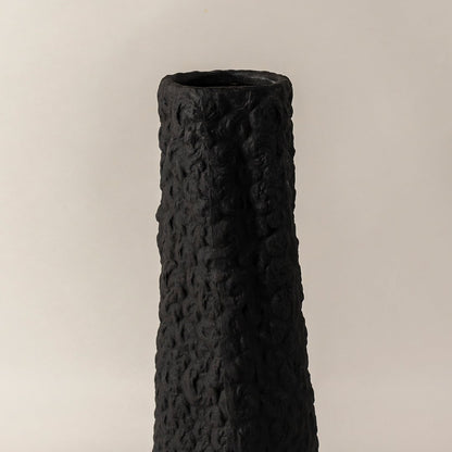 Closeup of black ceramic vase with handcrafted textured surface highlighting artistic detail perfect for home decoration.