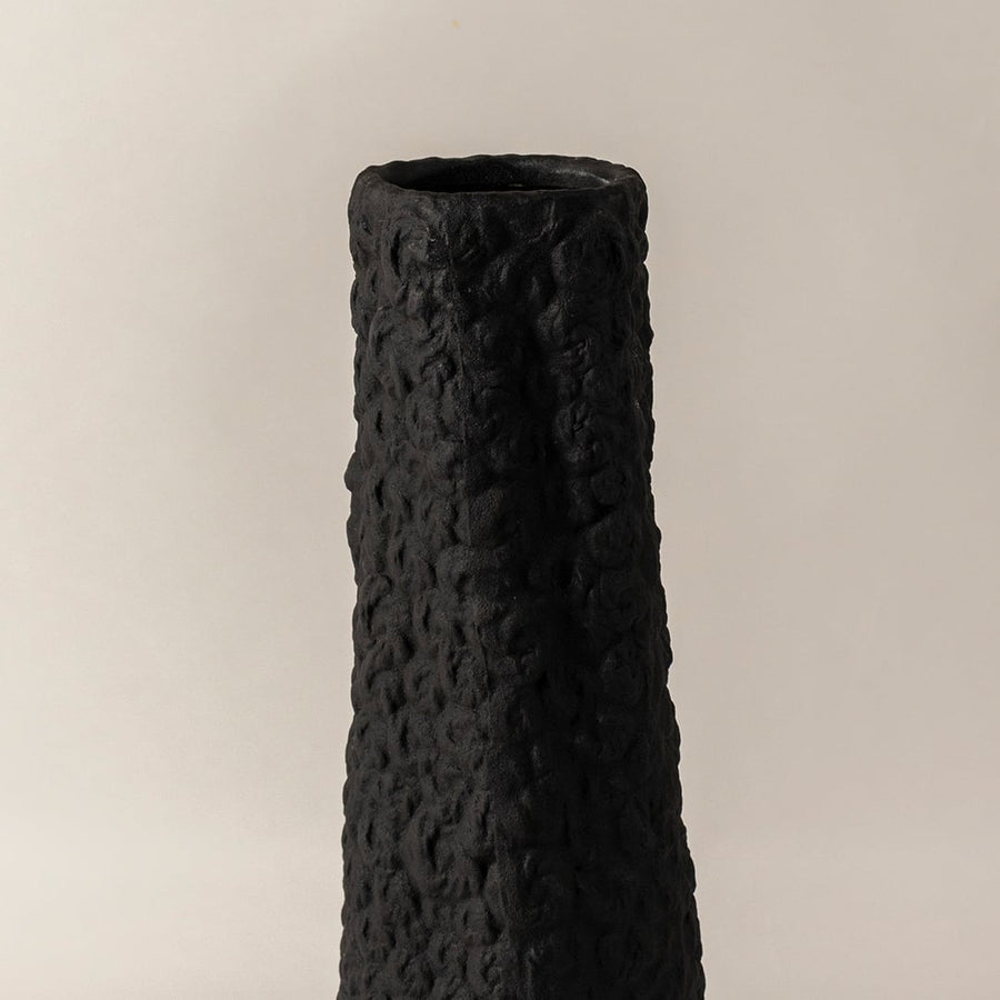 Closeup of black ceramic vase with handcrafted textured surface highlighting artistic detail perfect for home decoration.