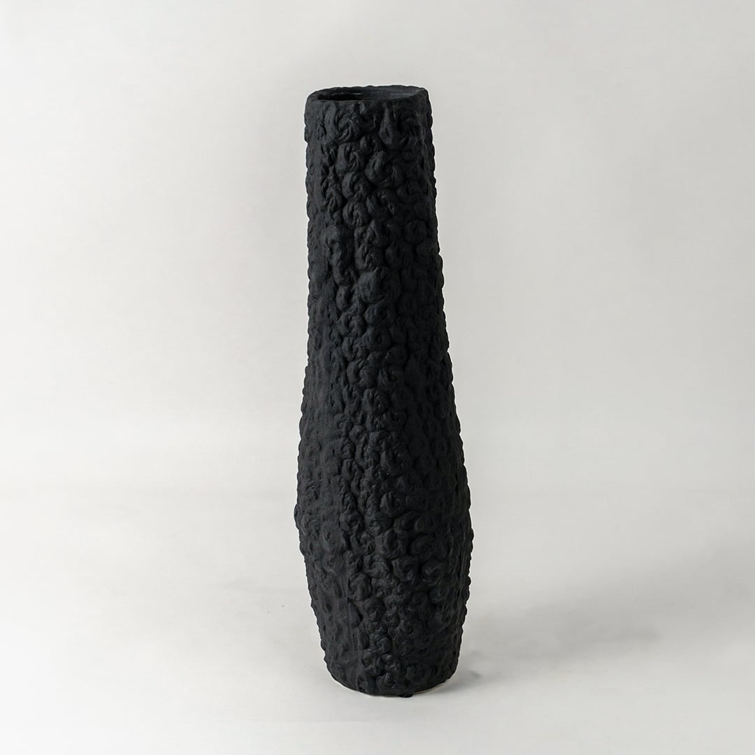 Elegant tall black textured ceramic vase ideal for contemporary shelf and corner decoration on plain white background surface.